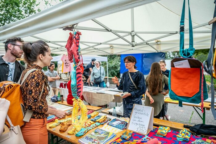 Menschen an einem Marktstand mit Kunstgegenständen