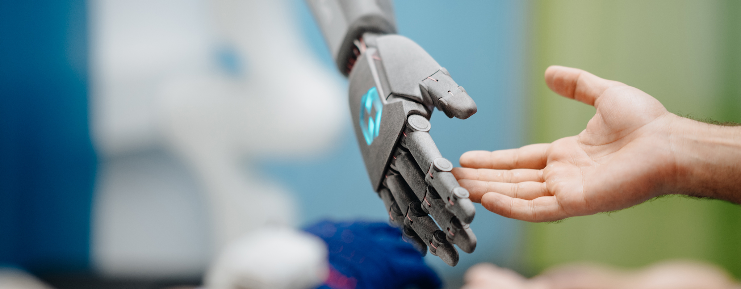 Eine Roboterhand macht einen Handschlag mit einem Menschen